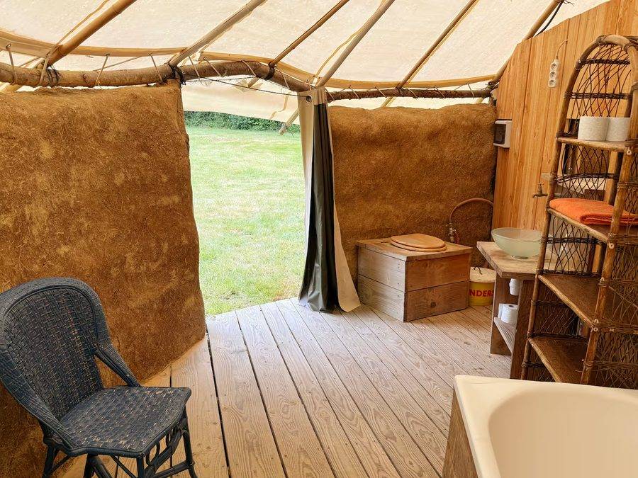 Intérieur de la case africaine, murs en argile et ouverture sur le pré