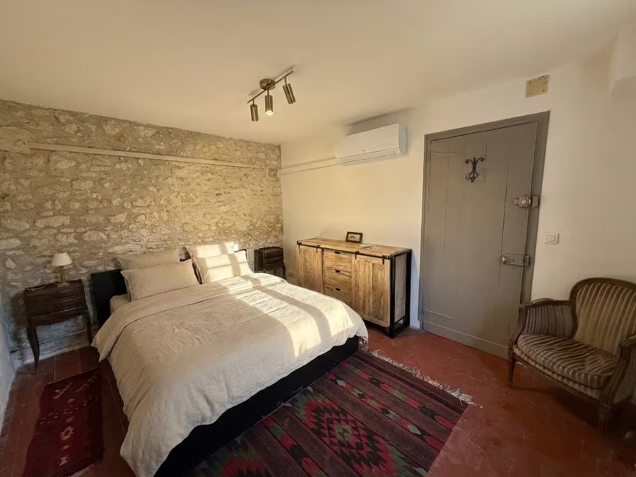 Chambre du gîte avec lit double et murs en pierre