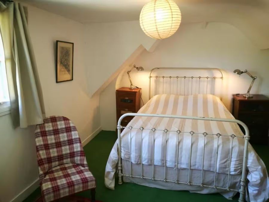 Chambre du gîte avec un lit en fer forgé ancien