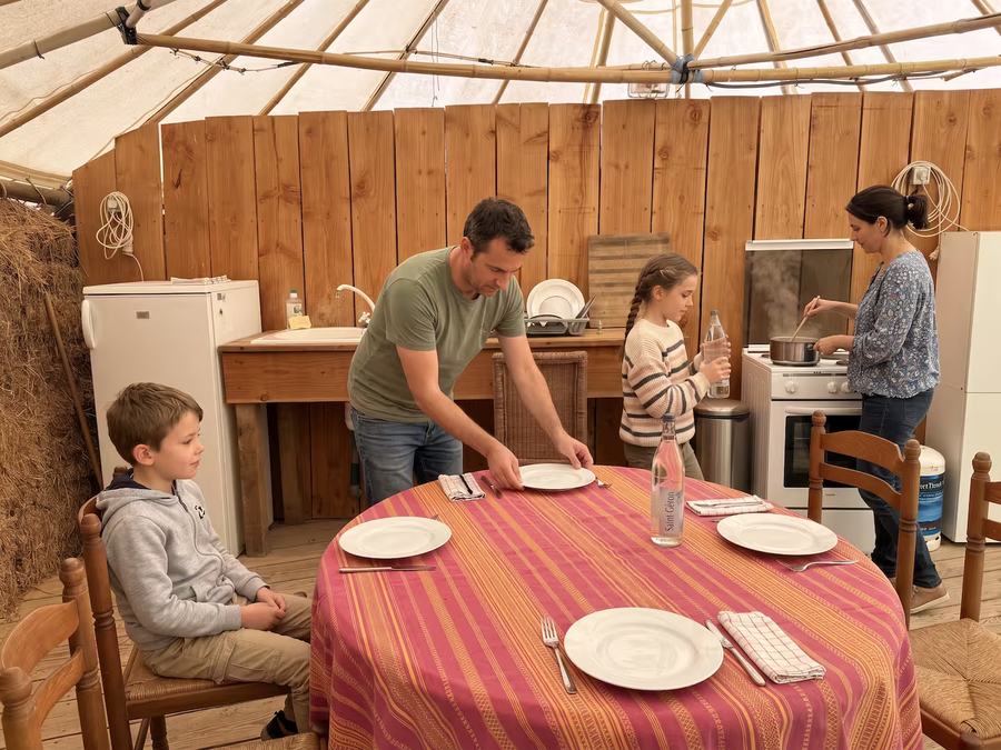 Une famille prépare le repas dans la cuisine de la case